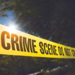 Police Tape in front of trees.