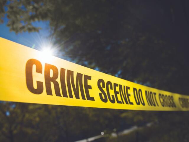 Police Tape in front of trees.