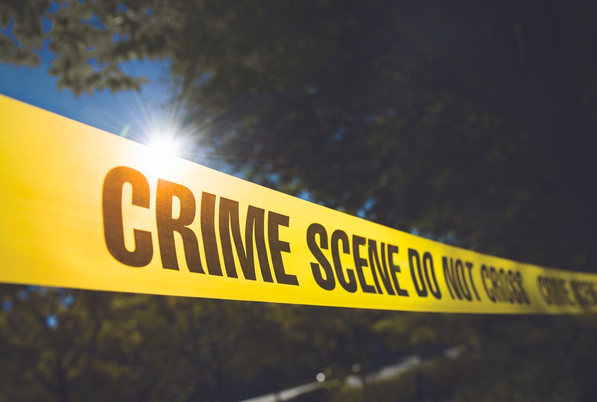 Police Tape in front of trees.