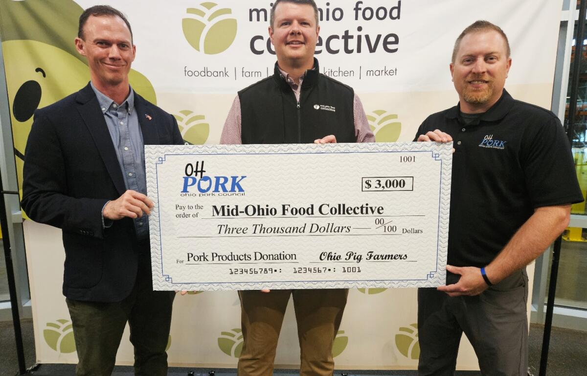 Three men hold a large check for $3,000 to Mid-Ohio Food Collective at a charity event.