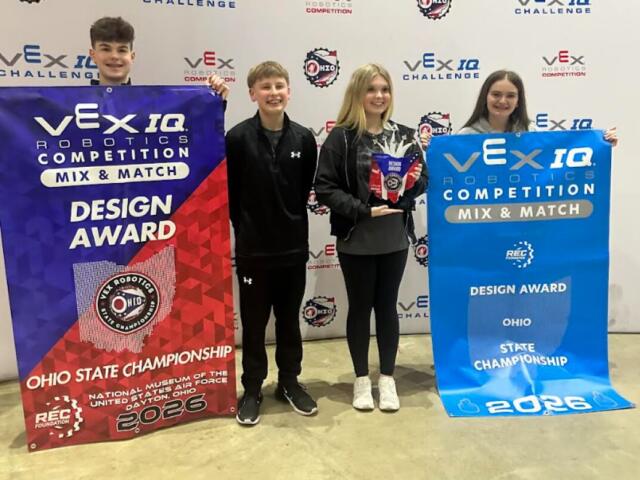 Four young robotics competitors pose with VEX IQ banners, holding a Design Award trophy at the Ohio State Championship 2026.