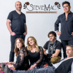 Six-member band posing for a promotional photo, logo StevieMac at top against a light backdrop (Fleetwood Mac & Stevie Nicks tribute).