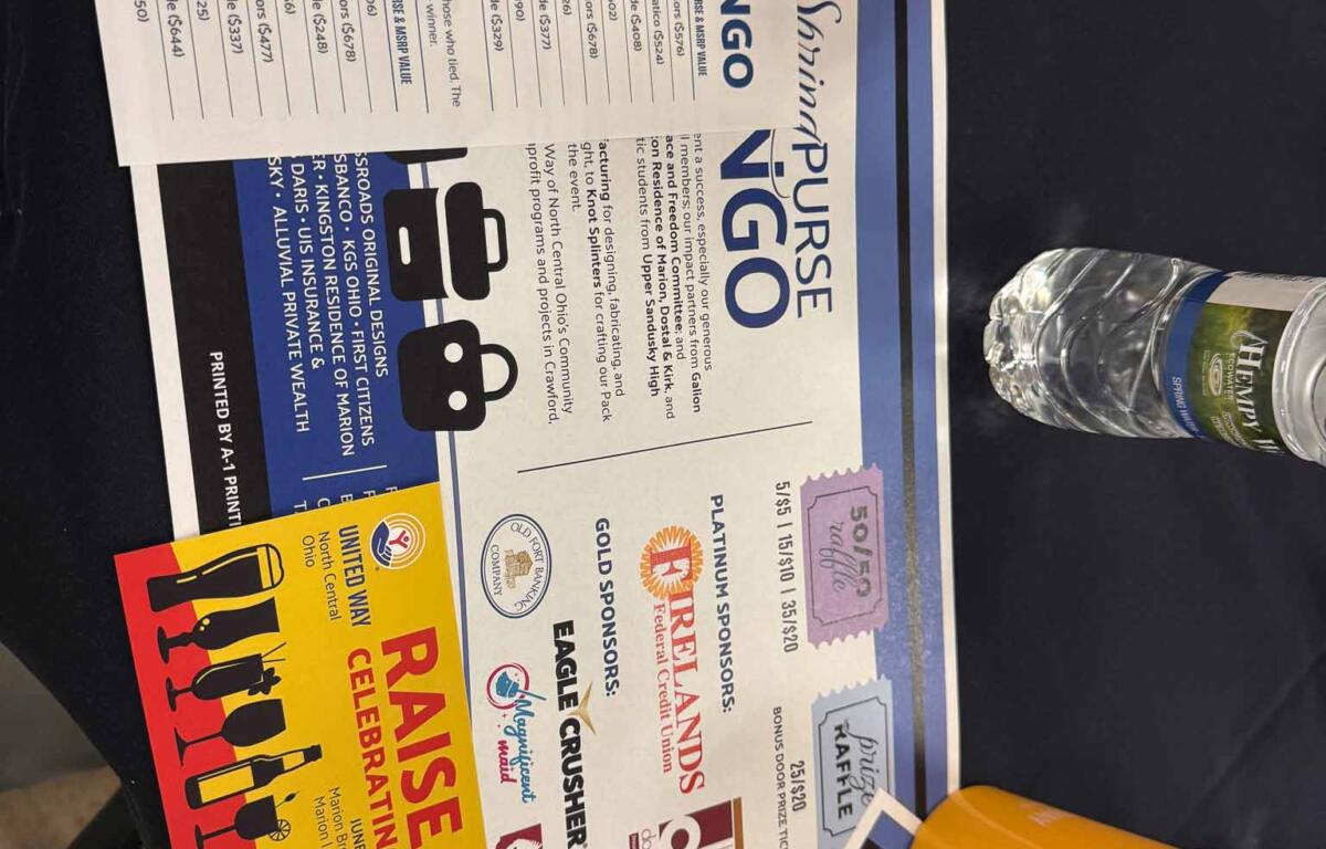 Colorful event flyers spread on a dark table with a yellow plastic cup nearby; includes NOW branding on one sheet.
