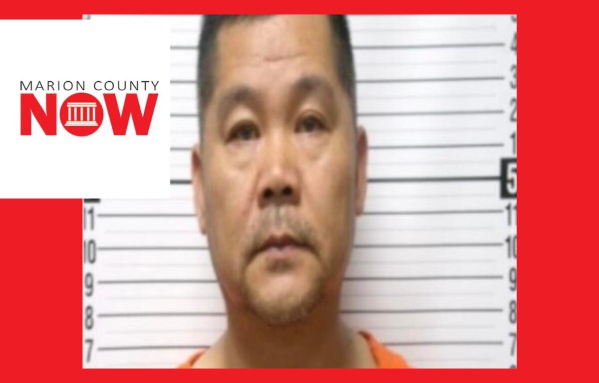 Mugshot-style photo of a man in an orange jumpsuit standing against a height chart; Marion County NOW logo overlays the left side.