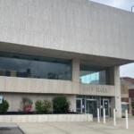 City Hall building with a beige stone facade and glass entrance, 'CITY HALL' over the doors.