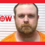 Mugshot of a bearded man in an orange jumpsuit standing against a height-chart wall, with a Marion County NOW logo on the left.