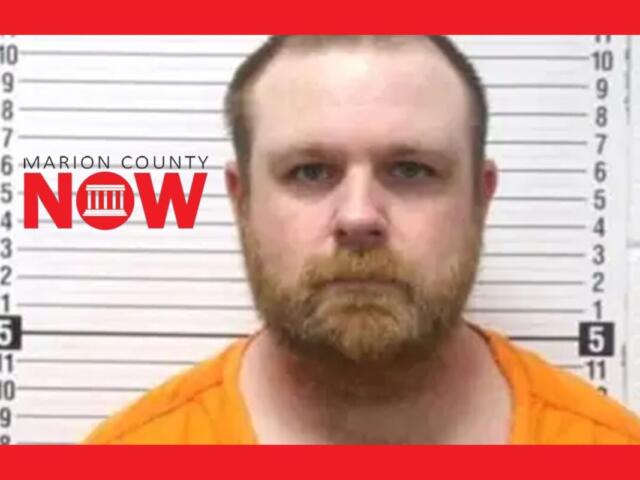 Mugshot of a bearded man in an orange jumpsuit standing against a height-chart wall, with a Marion County NOW logo on the left.